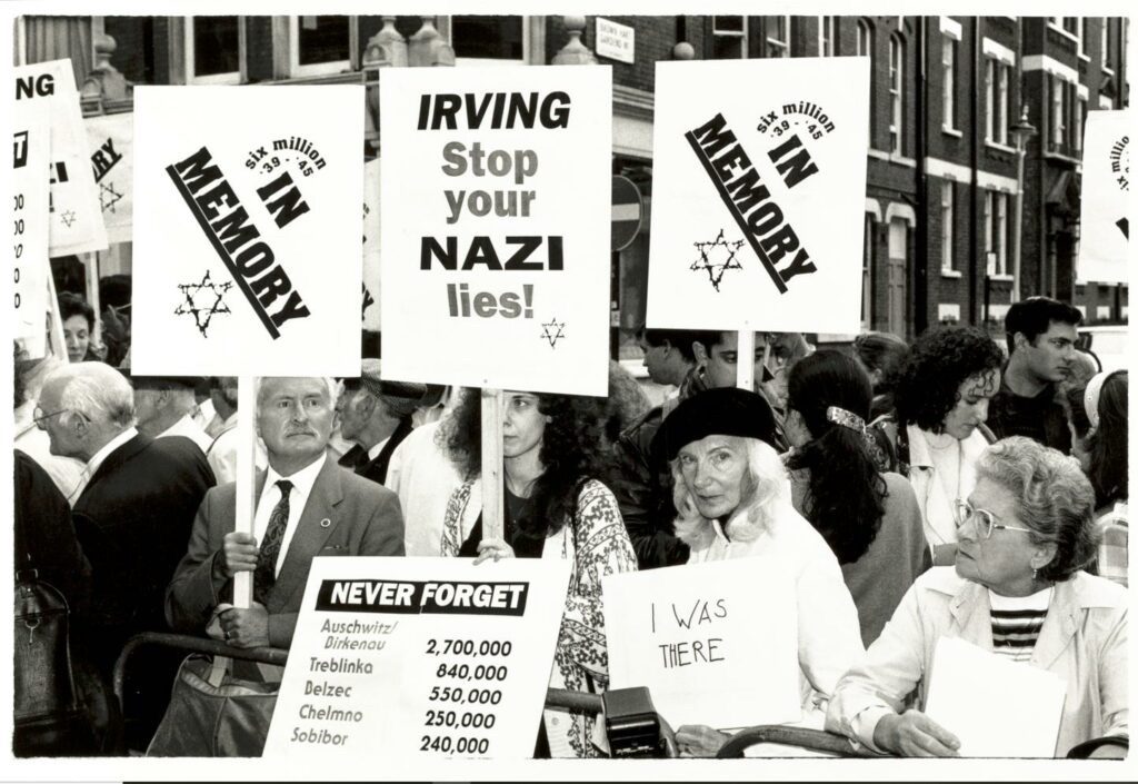 Black and white photograph of people protesting and holding up signs.