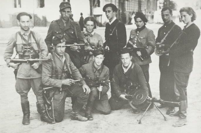 Black and white Photograph of a group of Jewish Lithuanian Partisans posing with guns.